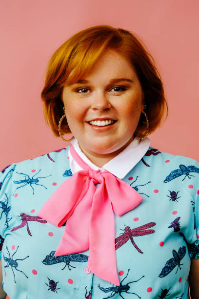 istock smiling young woman portrait in studio over pink background 1367997935