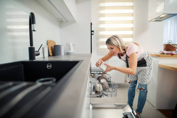 istock A tidy woman putting dishes into a dishwasher in her kitchen. 1368000268