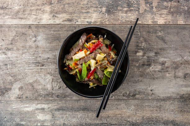 istock Beef, vegetables and sesame seeds in black bowl 1368000803