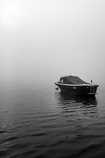 sloop on the lake at morning fog in black and white