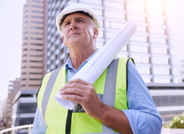 istock Cropped shot of a handsome mature male construction worker carrying blueprints while standing outside 1368003466
