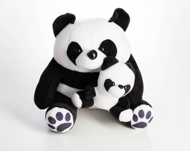 istock Children's soft toy black and white panda with a cub on a white background, close-up 1368003572