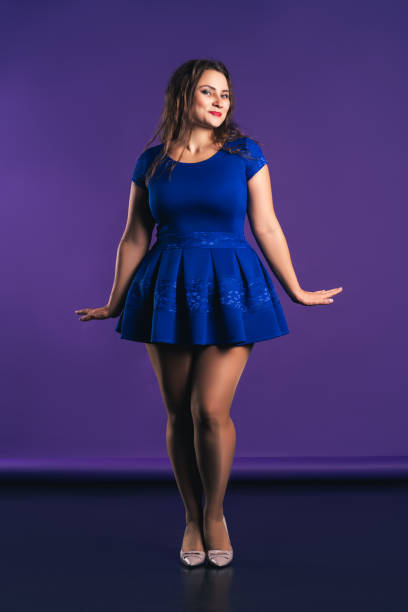 happy plus size model in blue dress on purple background - sex symbol sensuality women overweight imagens e fotografias de stock