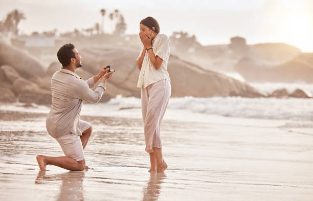 해변에서 그의 여자 친구에게 제안 하는 젊은 남자의 샷 - 약혼 반지 뉴스 사진 이미지