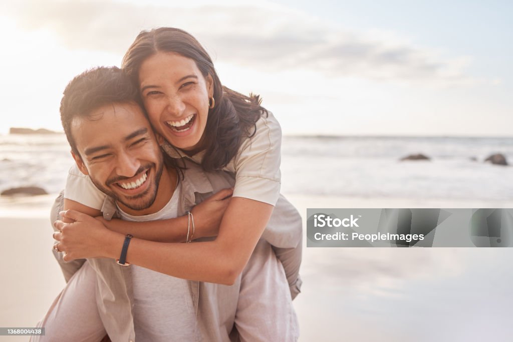 Shot of a couple enjoying a day at the beach He makes every day exciting Couple - Relationship Stock Photo