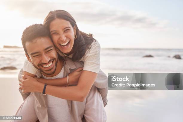 Shot Of A Couple Enjoying A Day At The Beach Stock Photo - Download Image Now - Couple - Relationship, Happiness, Smiling