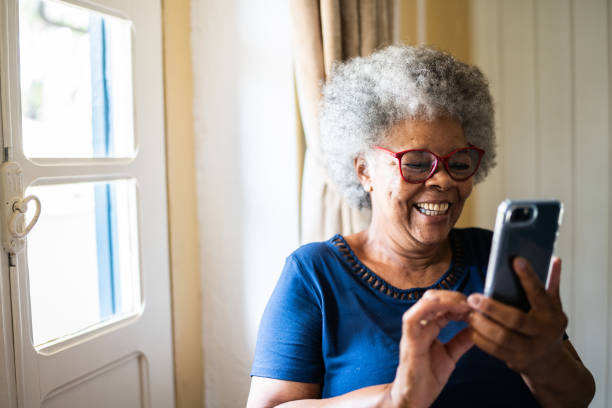 istock Senior woman using the mobile phone at home 1368004878