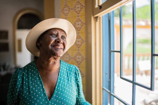 istock Contemplative senior woman looking through the window 1368004969