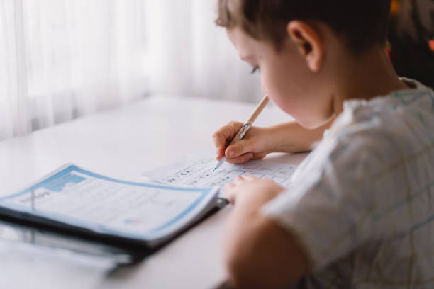 istock Distance learning education. Back to school. Cute kid boy studying at home and doing school homework. 1368004970