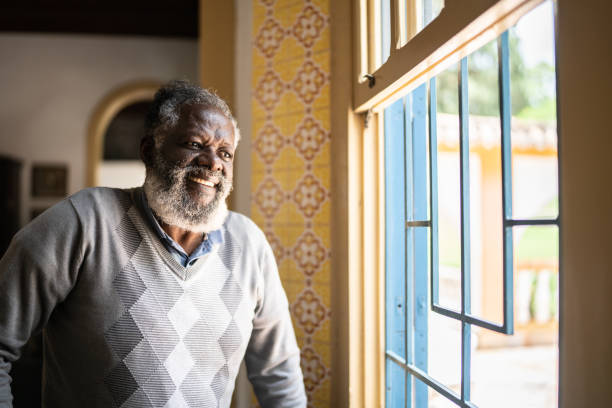 istock Contemplative senior man looking through the window 1368004989