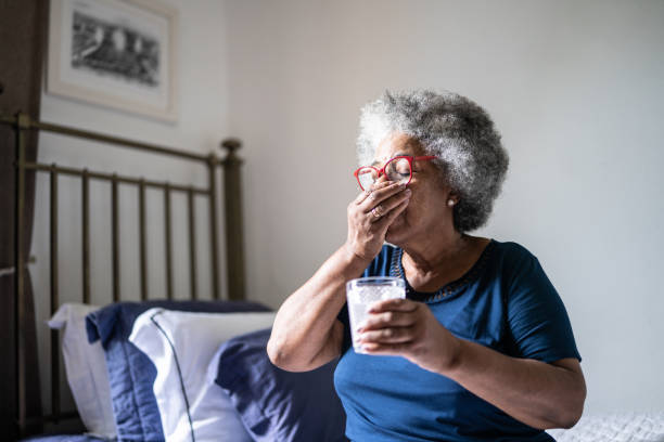 istock Senior woman taking medicines at home 1368005012