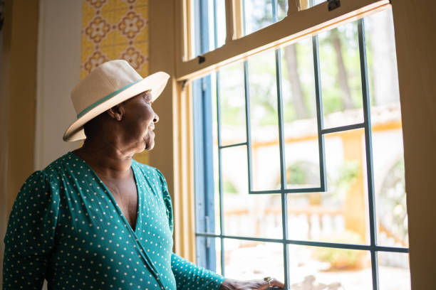 istock Contemplative senior woman looking through the window 1368005050