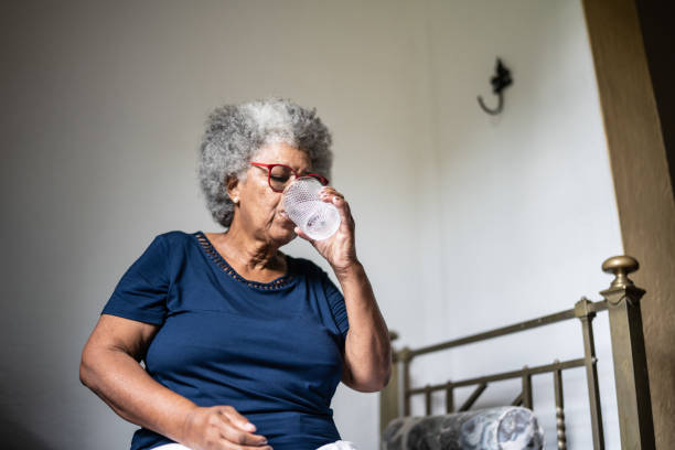 Senior woman drinking water at home