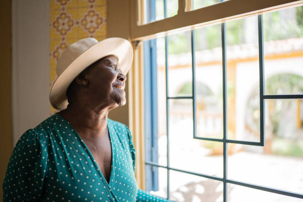 istock Contemplative senior woman looking through the window 1368005069