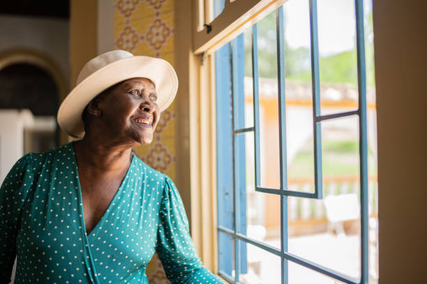 istock Contemplative senior woman looking through the window 1368005084