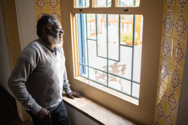 istock Contemplative senior man looking through the window 1368005090
