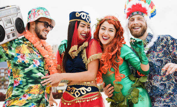 Happy dressed people celebrating at carnival party dancing together - Focus on faces