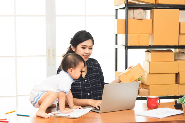 istock Beautiful Asian business mom is using a laptop  while spending time with her cute baby boy at home for quarantine from virus crisis, work from home concept. 1368008548