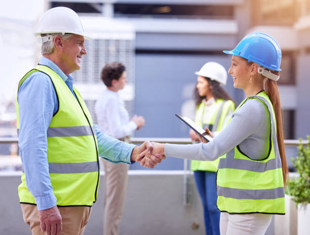 istock Cropped shot of two construction workers shaking hands while standing on a building site 1368008712
