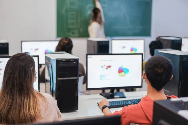 group of high school students hands up in computer class