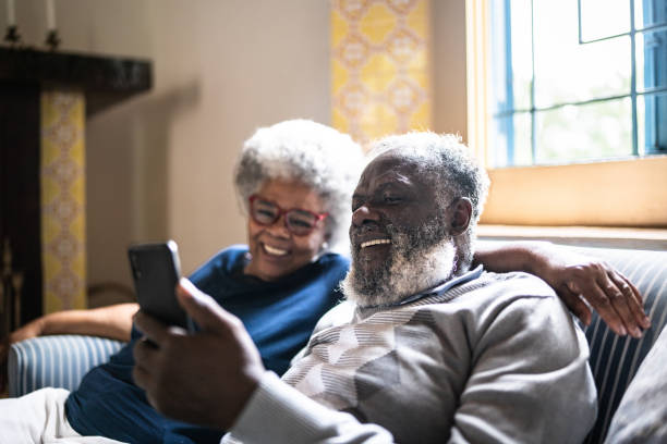 istock Senior couple using the mobile phone at home 1368009947