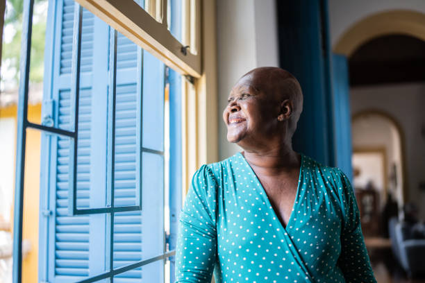 istock Contemplative senior woman looking through the window 1368010039