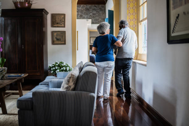 Wife helping husband walking at home