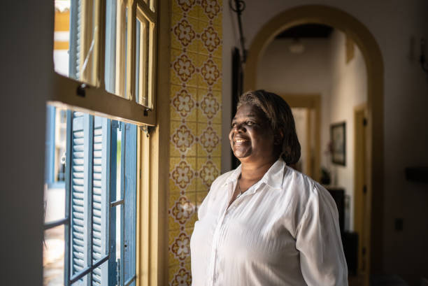 istock Contemplative senior woman looking through the window 1368010072