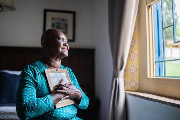 istock Senior woman holding a picture frame missing someone at home 1368010096