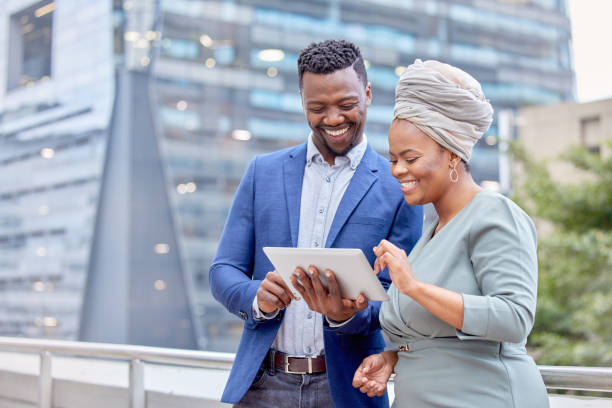 Shot of two colleagues using a digital tablet together against a city background