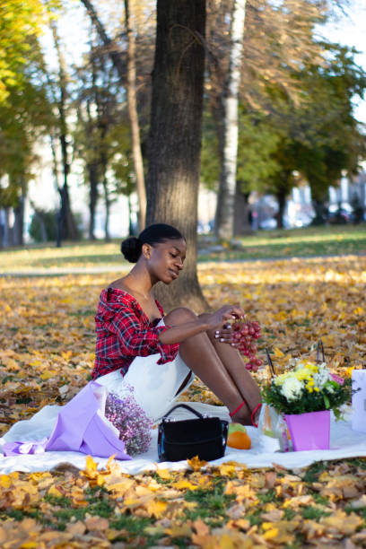 istock A beautiful African lady sitting on a floor in a park. 1368013397