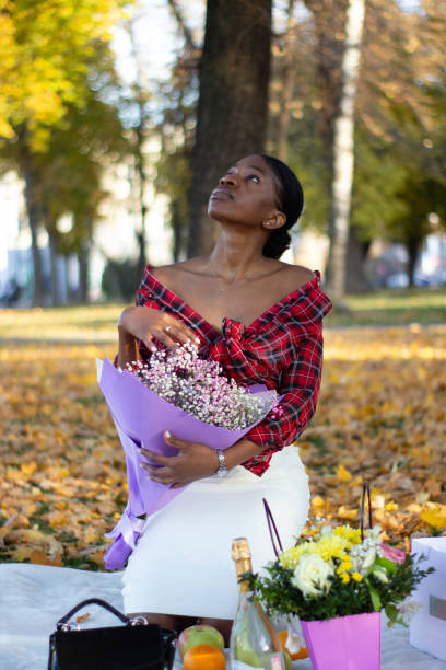 istock A beautiful African lady looking up at the sky in a park. 1368013598