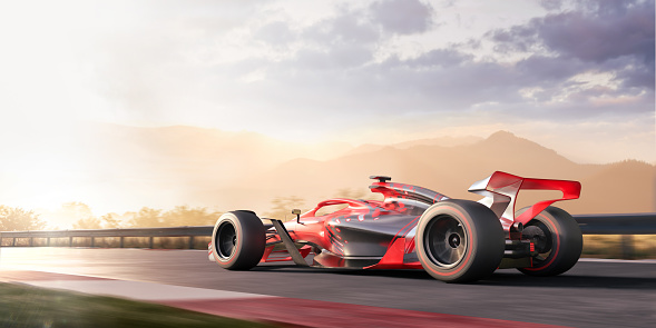 Low angle view of an unbranded racing car with generic markings moving at high speed along a straight section of race track at dawn. Sunlight bursts through mist in the foreground, causing bright reflections on the track. Mountains are visible in the distance. Location is fictional.