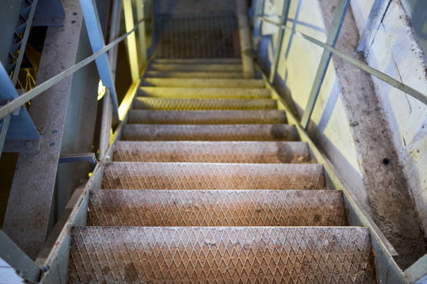 Example of chemical plant steampunk retro style interior part, with copyspace. Abstract image of industrial textured rusted stairs going down vertical or downstairs.