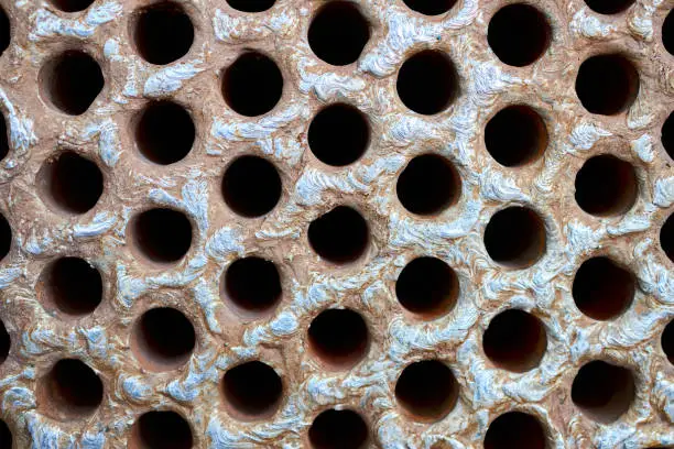 Photo of Tube sheet plate of heat exchanger or boiler closeup texture macro industrial background with insoluble hard mineral deposits salts scale welding seams and corrosion. Trypophobia concept.