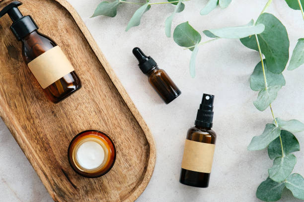istock Skin care cosmetics set with eucalyptus branches on stone table in bathroom top view. Amber glass beauty products packaging. Natural, eco organic cosmetics concept. 1368016072