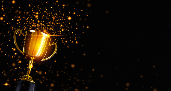 Champion golden trophy isolated on black background. Concept of success and achievement.