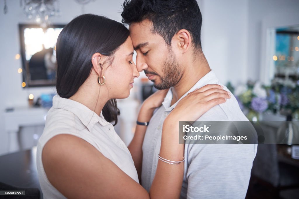 Shot of a young couple making up after an argument at home I'll always keep trying for us Couple - Relationship Stock Photo