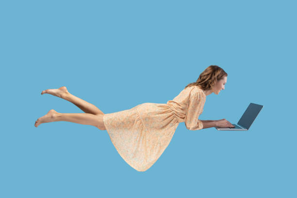 istock young woman levitating with laptop, reading good news message on computer while flying in mid-air. 1368017265