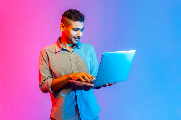 istock Man holding laptop in hand typing, blogger making posts in social networks, chatting with followers. 1368017376