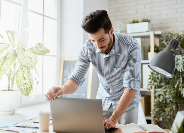 istock man working on a laptop at home. 1368017520