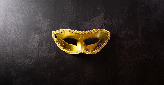 Above shoot of a venetian mask on a silky fabric and plenty of copy space.