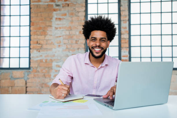 istock Portrait of a young man working on laptop 1368019323