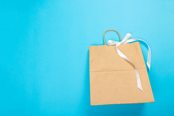 istock Paper bag for shopping on a blue background. Logo layout 1368019931