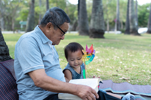 Ancianos asiáticos que tienen fe en el Señor, Dios leyendo la Biblia al aire libre con un niño photo