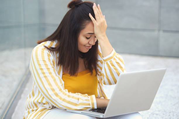 emoção negativa. retrato de uma linda mulher plus size estilosa 30-35 anos de idade em roupas amarelas, ter um problema, cometeu um erro, enquanto trabalha remotamente em um laptop nas férias - 30 35 years fotos - fotografias e filmes do acervo