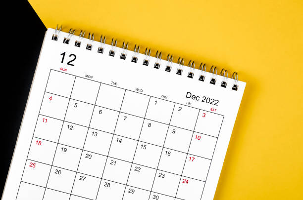 istock December 2022 desk calendar on yellow and black background. 1368022867