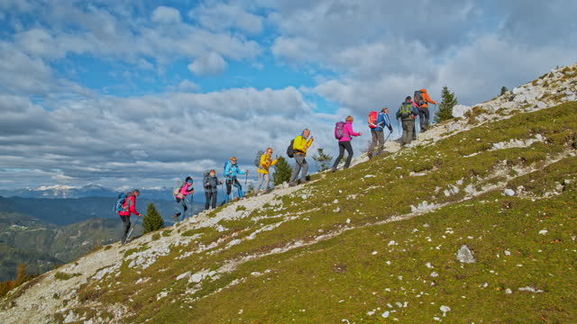 AERIAL Hikers going up a mountain slope on a sunny day