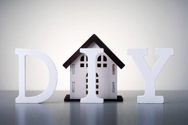 istock Home renovation construction diy concept. Word DIY with model of house on grey background. 1368024006
