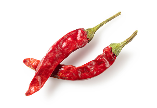 Dried chili peppers placed on a white background. View from directly above.